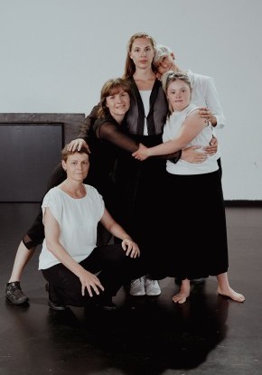Vier Frauen und ein Mädchen in einem innigen Gruppenbild. Sie legen ihre Arme um sich, halten sich oder legen den Kopf auf die Schulter.